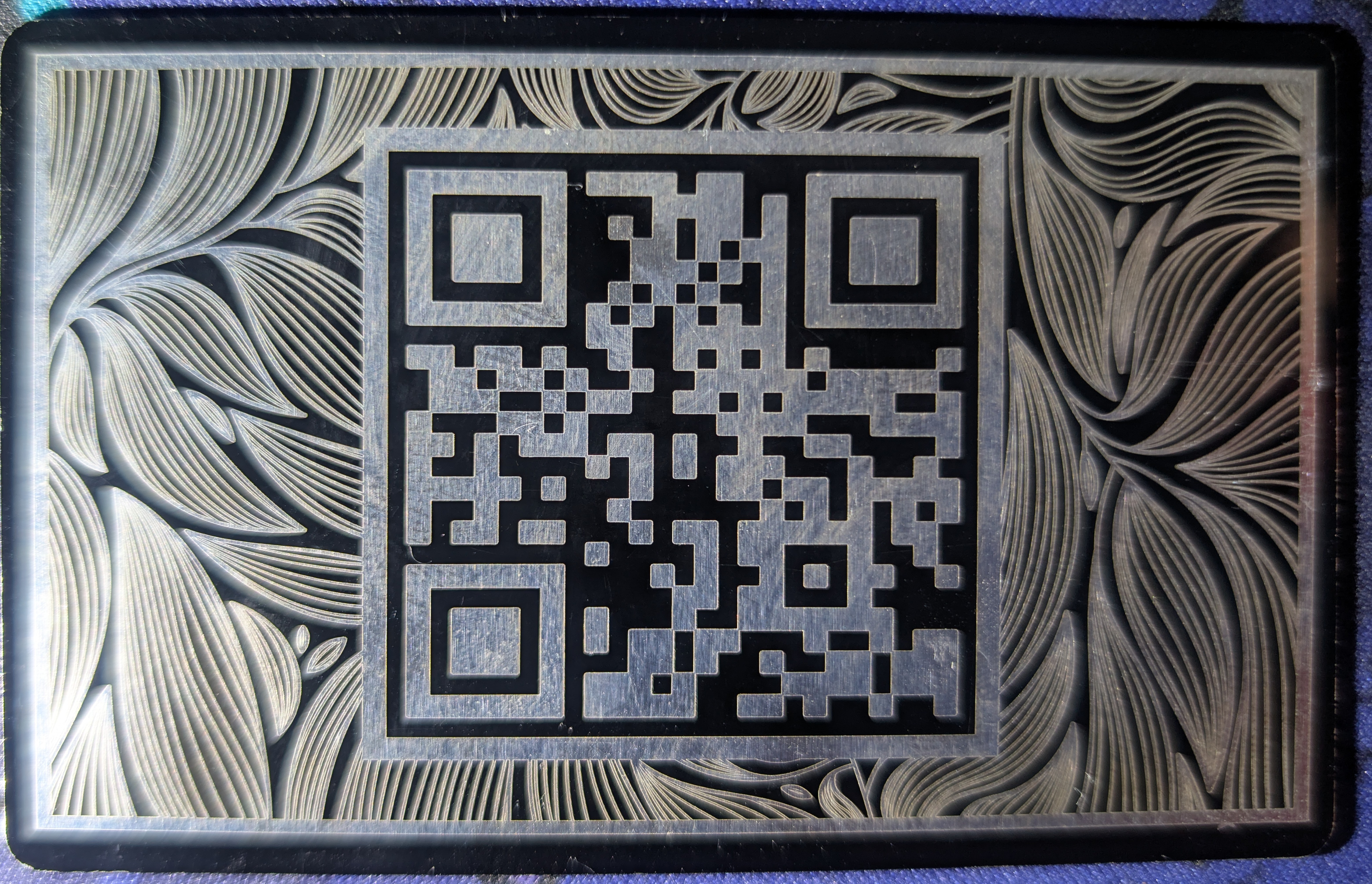 Black annodized aluminum card with a QR code on the back
